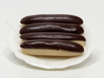 (image for) 4 Miniature Éclairs on White Ceramic Plate by Charlotte Willmott