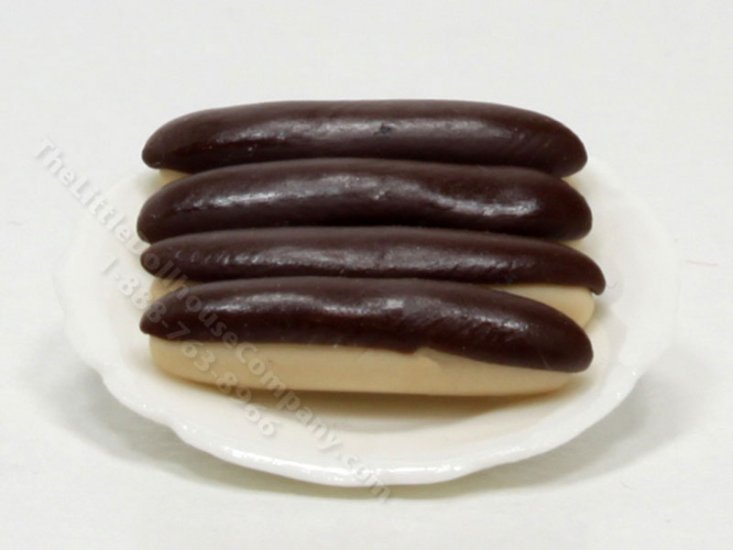 (image for) 4 Miniature Éclairs on White Ceramic Plate by Charlotte Willmott