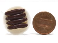 (image for) 4 Miniature Éclairs on White Ceramic Plate by Charlotte Willmott
